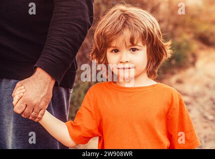 Die Hand des Vaters führt seinen Sohn, Vertrauen Sie Familienkonzept. Eltern halten die Hand eines kleinen Kindes. Kind Hand Vater. Hände von Eltern und Kind Stockfoto