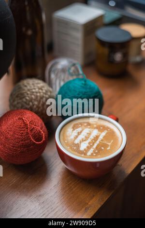 Rote Kaffeetasse mit Latte Art aus Kiefern auf rustikalem Holztisch Stockfoto
