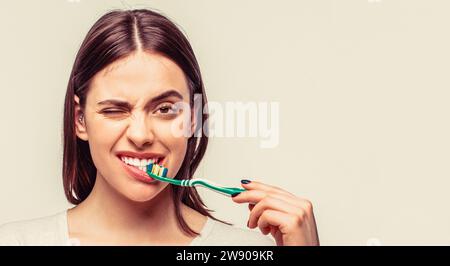 Porträt einer lächelnden, süßen Frau, die eine Zahnbürste hält. Lächelnde Frau mit gesunden, schönen Zähnen, die eine Zahnbürste hält Stockfoto