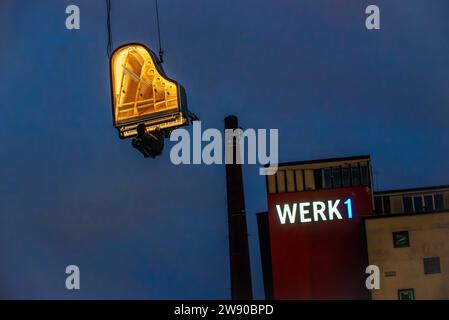 Piano Vertical, Alain Roche spielt frühmorgens am Kran hängend in luftiger Höhe Klavier, Werksviertel-Mitte, München, Dezember 2023 Deutschland, München, München, 23.12.2023, Pianist Alain Roche mit seinem Projekt PIANO VERTIKAL, spielt an einem Kran hängend unter dem Motto When the Sun steht still vor Sonnenaufgang Klavier, hängt in 10 Metern Höhe in der Vertikalen, Konzert startete heute um 6:58 Uhr, im Werksviertel-Mitte am Bauplatz des künftigen Konzerthauses, Zuhörer in Liegestühlen lauschen bei strömendem Regen, Sturm und Temperaturen von 4 Grad mit Kopfhörern der Musik, über Mikrofon, die in g Stockfoto