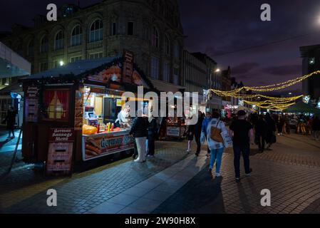 Deutscher Wurstverkäufer Weihnachtsmarkt und Weihnachtsbeleuchtung in der High Street von Southend on Sea, Essex, Großbritannien. Am späten Nachmittag, abends Einkäufer Stockfoto