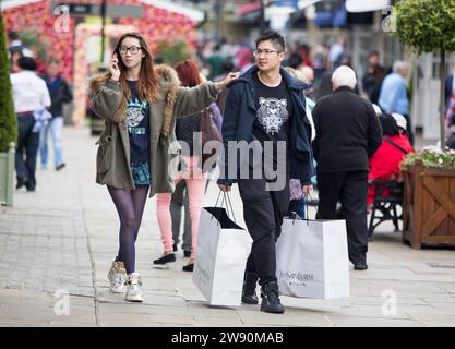 Chinesische Besucher des Bicester Village Einzelhandelsgeschäfts in Oxfordshire. Stockfoto