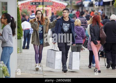 Chinesische Besucher des Bicester Village Einzelhandelsgeschäfts in Oxfordshire. Stockfoto