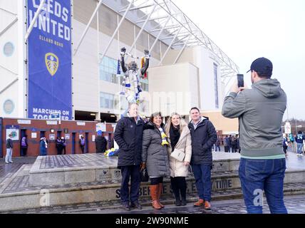 Die Fans posieren für ein Foto neben der Billy Bremner Statue vor dem Sky Bet Championship Match in der Elland Road, Leeds. Bilddatum: Samstag, 23. Dezember 2023. Stockfoto
