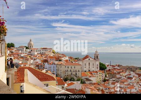 Blick auf den Fluss über rote Dächer alter Gebäude im wunderschönen Viertel Alfama, Lissabon, Portugal, Europa. Stockfoto