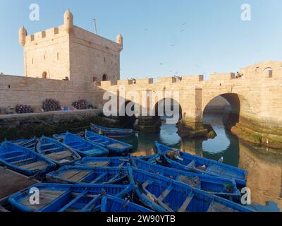 Blaue Fischerboote am Hafen bei der Festung an einem Winterabend in Essaouira, Marokko. Dezember 2023 Stockfoto