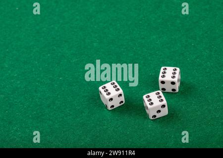 Drei weiße Würfel auf dem Green Velvet Casino Tisch für Spiele und Glücksspiele Stockfoto