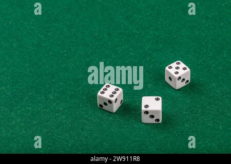 Drei weiße Würfel auf dem Green Velvet Casino Tisch für Spiele und Glücksspiele Stockfoto