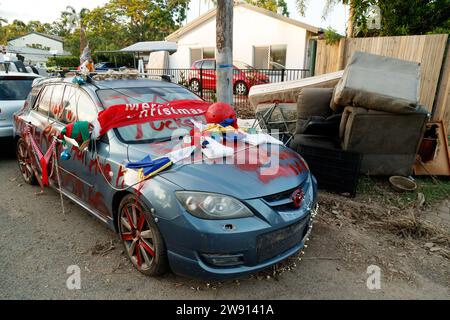 Cairns, Australien. Dezember 2023. Ein Auto, das während der Überschwemmung am Holloways Beach in Cairns am 17. Und 18. Dezember vollständig überflutet wurde, wurde mit besprühten Nachrichten und Weihnachtsschmuck geschmückt. 21. Dezember 2023 in Cairns, Australien. Solche weit verbreiteten großen Überschwemmungen in Cairns sind in der Geschichte nicht bekannt. (Foto: Joshua Prieto/SIPA USA) Credit: SIPA USA/Alamy Live News Stockfoto