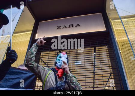 London, Großbritannien. Dezember 2023. Demonstranten vor Zara in der Oxford Street. Propalästinensische Demonstranten marschierten vor Weihnachten durch Londons Einkaufsviertel und forderten einen Waffenstillstand. In der Oxford Street. Quelle: Vuk Valcic/Alamy Live News Stockfoto