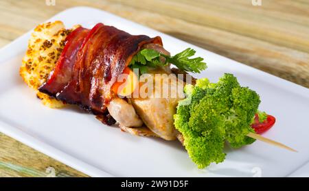 Gegrillte Wachteln im Jamon auf Spieß mit Gemüse Stockfoto