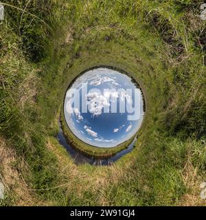 Blauer Loch Kugel kleiner Planet im grünen Gras runden Rahmen Hintergrund Stockfoto