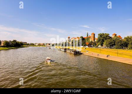 Weitwinkelaufnahme eines Motorboots, das auf der weichsel neben der Burg wawel in der Stadt Krakau in Polen, Europa, segelt Stockfoto