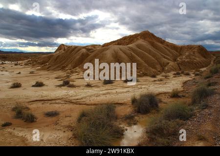 Unter einem stürmischen Oktoberhimmel, Blick auf einen Mini-Canyon, der in die Tonschichten von Bardena Blanca in den Bardenas Reales (Spanisch Navarra) gegraben wurde Stockfoto