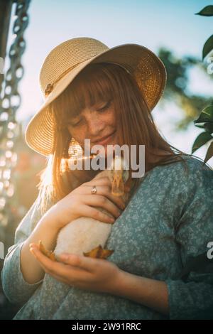 Eine junge Frau mit Hut, die Entlein hält Stockfoto