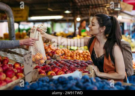 Frau, die frisches Obst und Gemüse auf dem Stadtmarkt kauft Stockfoto