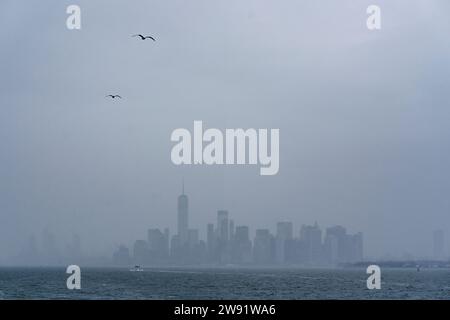 Wolkenkratzer in der Nähe des Hudson River unter dem nebeligen Himmel in New York City Stockfoto