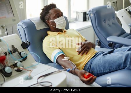 Mann mit Schutzmaske, der Blut spendet Stockfoto
