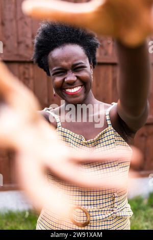 Fröhliche junge Frau, die draußen Gesten macht Stockfoto