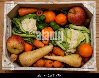 Stockbild einer Kiste mit frischem Obst und Gemüse, einschließlich Karotten, Blumenkohl, Pastinaken, Rosenkohl, Äpfel und Orangen. Bilddatum: Freitag, 22. Dezember 2023. Stockfoto