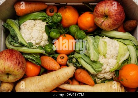 Stockbild einer Kiste mit frischem Obst und Gemüse, einschließlich Karotten, Blumenkohl, Pastinaken, Rosenkohl, Äpfel und Orangen. Bilddatum: Freitag, 22. Dezember 2023. Stockfoto