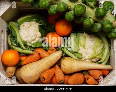 Stockbild einer Kiste mit frischem Obst und Gemüse, einschließlich Karotten, Blumenkohl, Pastinaken, Rosenkohl, Äpfel und Orangen. Bilddatum: Freitag, 22. Dezember 2023. Stockfoto