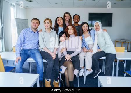 Lächelnde multiethnische Schüler mit Armen im Klassenzimmer Stockfoto