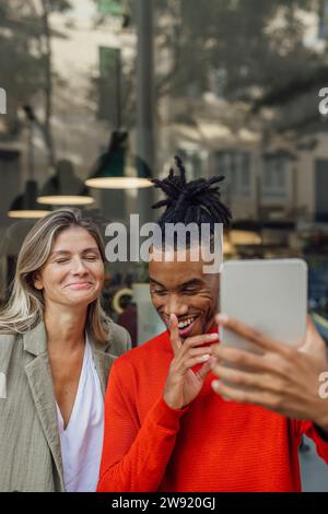 Lächelnde Geschäftsfrau mit Kollegen, die Videoanrufe auf einem Tablet-PC durchführen Stockfoto