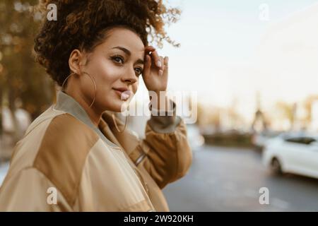 Lächelnde Frau mit Creolen auf der Straße Stockfoto