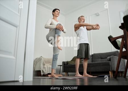 Ein Paar macht Dehnungsübungen am Morgen zu Hause Stockfoto