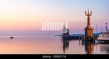 Deutschland, Baden-Württemberg, Konstanz, Hafen am Bodensee bei Sonnenaufgang mit Imperia-Statue im Vordergrund Stockfoto