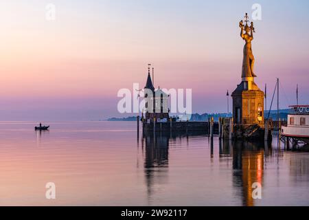 Deutschland, Baden-Württemberg, Konstanz, Hafen am Bodensee bei Sonnenaufgang mit Imperia-Statue im Vordergrund Stockfoto