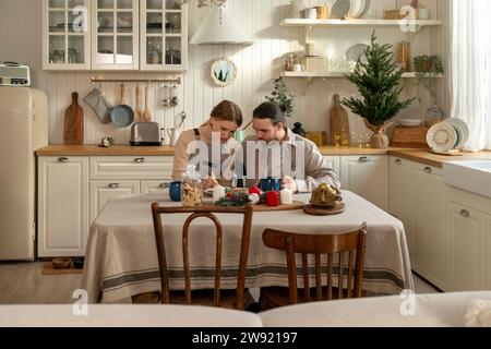 Ein paar dekorierende Kekse auf dem Tisch in der Küche zu Hause Stockfoto