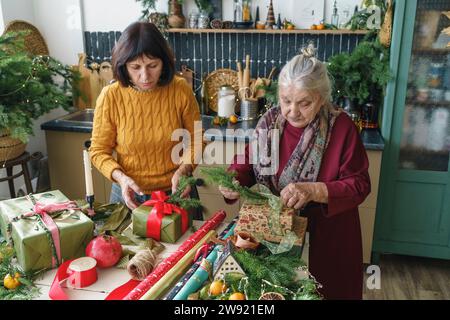 Seniorin verpackt Weihnachtsgeschenke mit Mutter zu Hause Stockfoto