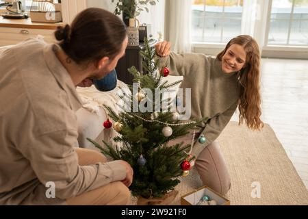Glückliches Paar dekorieren Weihnachtsbaum zu Hause Stockfoto
