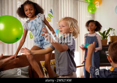 Glückliche Kinder, die zu Hause mit Ballons spielen Stockfoto