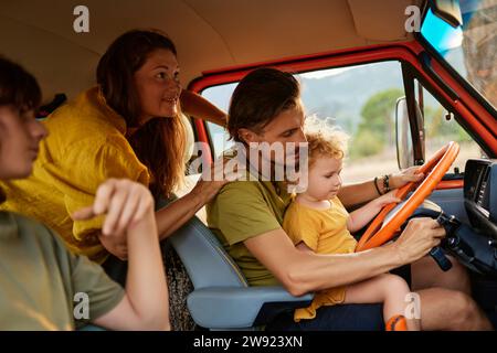 Reifer Mann sitzt mit Familie im Wohnwagen im Urlaub Stockfoto