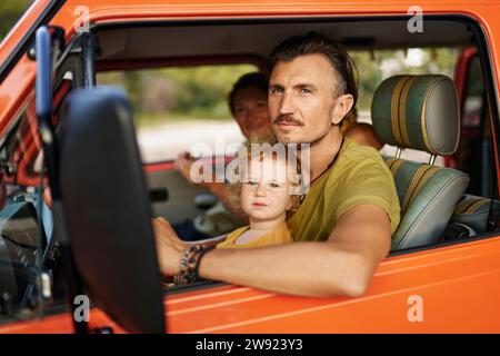 Eltern mit Tochter sitzen im Urlaub in einem Wohnwagen Stockfoto