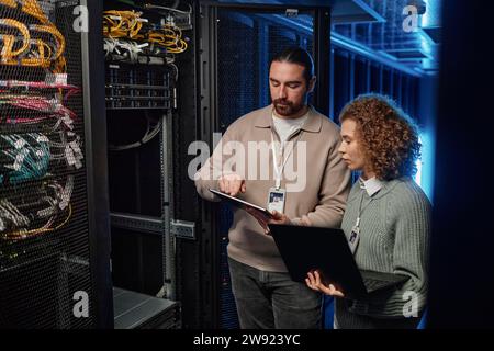 IT-Experten diskutieren über Tablet-PCs im Serverraum Stockfoto