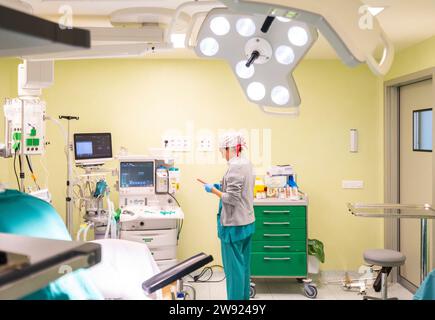 Krankenschwester mit Smartphone in der Nähe medizinischer Geräte im OP Stockfoto