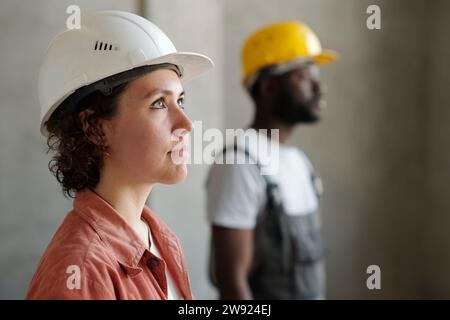 Ingenieur trägt einen Schutzhelm mit einem Kollegen im Hintergrund Stockfoto