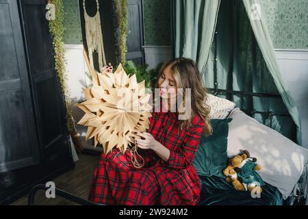 Frau mit sternförmiger Weihnachtsdekoration zu Hause Stockfoto