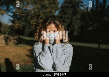Frau, die das Gesicht mit einem Rollkragenpullover bedeckt Stockfoto