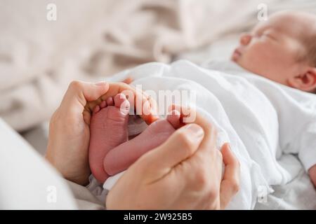 Mutter hält die Füße des neugeborenen Sohnes in der Hand Stockfoto