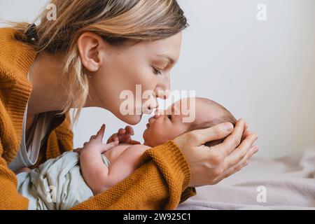 Mutter hält und küsst den Jungen zu Hause Stockfoto