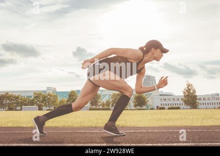 Der Profi-Läufer steht auf der Strecke und bereitet sich auf den Start des Rennens vor. Sportkonzept. Gemischte Medien Stockfoto