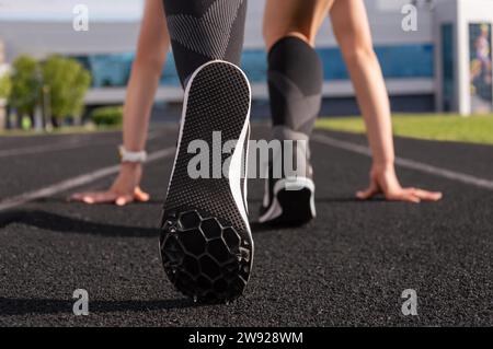 Der Profi-Läufer steht auf der Strecke und bereitet sich auf den Start des Rennens vor. Sportkonzept. Gemischte Medien Stockfoto