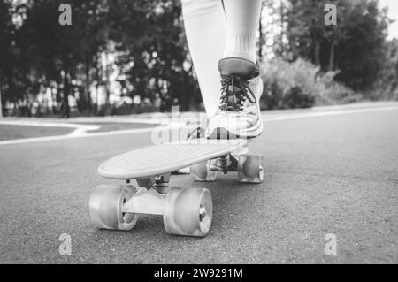 Bilder eines Beins, das auf einem Skateboard steht. Sonniger Abend im Park. Skateboarding-Konzept. Gemischte Medien Stockfoto