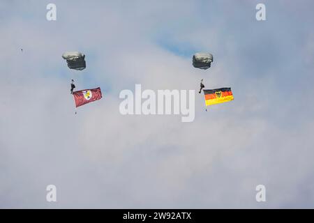 Fallschirmspringer der Bundeswehr mit deutscher Flagge. Spottertag zum Tag der Bundeswehr auf dem Armeeflugplatz Bueckeburg, Niedersachsen Stockfoto