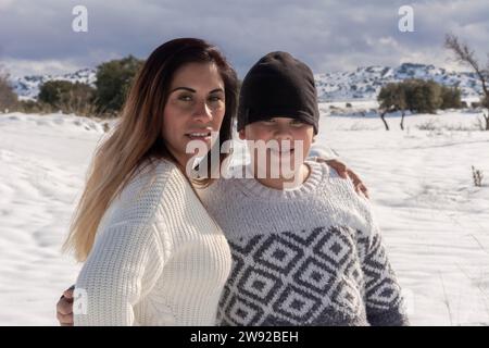 Porträt von Mutter und Kind in der Kamera im verschneiten Feld Stockfoto